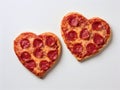 Delicious baked pizzas in the shape of a heart, with various vegetables and sausage, on a white background