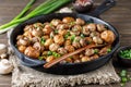 Delicious baked potatoes in cast-iron pan with champignons and green onion. Dish for dinner Royalty Free Stock Photo