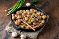 Delicious baked potatoes in cast-iron pan with champignons and green onion. Dish for dinner Royalty Free Stock Photo