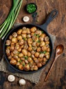 Delicious baked potatoes in cast-iron pan with champignons and green onion. Dish for dinner Royalty Free Stock Photo