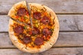 Delicious baked salami pizza served on rustic wooden table Royalty Free Stock Photo