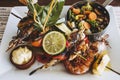 Barbecued fish and vegetable seafood dish in a white plate