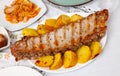 Barbecued pork spare ribs with baked potatoes on plate Royalty Free Stock Photo
