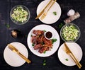 Delicious barbecued spare ribs on plate on dark background.