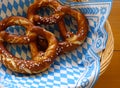 Delicious Bavarian Brezeln or pretzels with a brown salty crust on a traditional Bavarian cocktail napkin in a basket