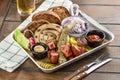 Delicious bbq Fried sausages with cabbage, pickles and potato on platter and glass of beer on wooden table Royalty Free Stock Photo