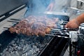 delicious bbq kebab grilling on open grill, outdoor kitchen. food festival in city. tasty food roasting on skewers, food-court. Royalty Free Stock Photo