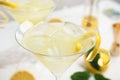 Delicious bee`s knees cocktail with ice and lemon twist on white table, closeup