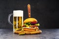 Delicious beef burger on a wooden board with a glass of beer.