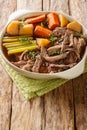 Delicious beef pot roast with potatoes, celery and carrots with thyme and rosemary closeup in the bowl. Vertical Royalty Free Stock Photo