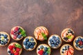 Delicious berry tartlets or cake with cream cheese decorated lemon peel and mint leaf from above. Tasty pastry desserts. Royalty Free Stock Photo