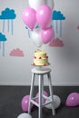 delicious birthday cake with balloons arranged in decorated room