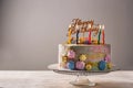 Delicious birthday cake with candles on table against grey background Royalty Free Stock Photo