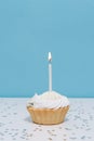 Delicious birthday Cupcake With One Candle on table on a blue isolated background. boy\'s first birthday Royalty Free Stock Photo