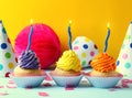 Delicious birthday cupcakes with burning candles on table against color background Royalty Free Stock Photo