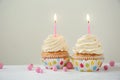 Delicious birthday cupcakes with burning candles on white wooden table Royalty Free Stock Photo