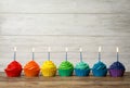 Delicious birthday cupcakes with burning candles on wooden table Royalty Free Stock Photo