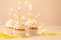 Delicious birthday cupcakes with burning candles on wooden table  against blurred lights Royalty Free Stock Photo