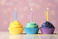 Delicious birthday cupcakes with cream and candles on table Royalty Free Stock Photo
