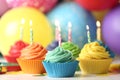 Delicious birthday cupcakes with cream and burning candles Royalty Free Stock Photo