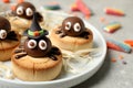 Delicious biscuits with chocolate spiders on light grey table, closeup. Halloween celebration