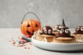 Delicious biscuits with chocolate spiders on light grey table. Halloween celebration