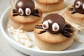 Delicious biscuits with chocolate spiders in tray, closeup. Halloween celebration