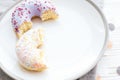 Delicious bite of donuts with colorful sprinkles on stylish plate on white table with confetti. Party concept. No diet. Candy bar