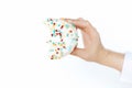 Delicious bitten donut in hand on background of white wall in room. Celebrating birthday. Diet Royalty Free Stock Photo