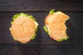 Delicious bitten hamburger on wooden background, shot from upper view