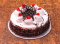 Delicious Black forest cake decorated with whipped cream and cherries isolated on dark wooden background top view Royalty Free Stock Photo