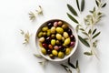 Delicious black, green and red olives with leaves in a bowl, isolated on white background, view from above. AI generated Royalty Free Stock Photo