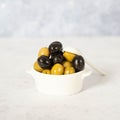 Delicious black, green and red olives with leaves in a wooden bowl Royalty Free Stock Photo