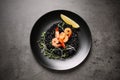 Delicious black risotto with shrimps and lemon on table, top view. Food photography Royalty Free Stock Photo