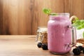 Delicious blackberry smoothie in mason jar and berries on wooden table. Space for text Royalty Free Stock Photo