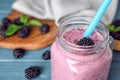 Delicious blackberry smoothie in mason jar on blue wooden table. Space for text Royalty Free Stock Photo