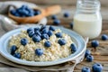 Delicious blueberry oatmeal with milk served on elegant white plate on vintage wooden table Royalty Free Stock Photo