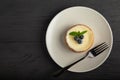 Delicious blueberry tartlet or cake with vanilla cream and mint on a white plate with black fork, copy space, top view Royalty Free Stock Photo