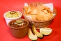 Delicious bowl of traditional Mexican Guacamole, nachos and guacamole ingredients: Avocado, onion, cilantro, hot pepper tomatoes Royalty Free Stock Photo