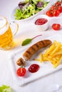 Delicious bratwurst with rolls and beer