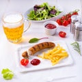 Delicious bratwurst with rolls and beer