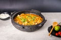 Delicious Brazilian fish moqueca with tomato, onion, olive oil, coriander and orocum seed. Made in clay pot on white table and Royalty Free Stock Photo