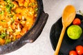 Delicious Brazilian fish moqueca with tomato, onion, olive oil, coriander and orocum seed. Made in clay pot on white table and Royalty Free Stock Photo