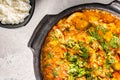 Delicious Brazilian fish moqueca with tomato, onion, olive oil, coriander and orocum seed. Made in clay pot on white table and Royalty Free Stock Photo