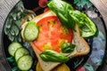 delicious bread with butter tomatoes, cucumbers and basil on a black plate Royalty Free Stock Photo