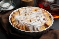 Delicious bread pudding with raisins, powdered sugar and tea on black table, closeup Royalty Free Stock Photo
