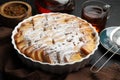 Delicious bread pudding with raisins, powdered sugar and tea on black table, closeup Royalty Free Stock Photo