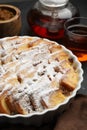 Delicious bread pudding with raisins, powdered sugar and tea on table, closeup Royalty Free Stock Photo