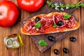 Delicious bread toast with natural tomato, extra virgin olive oil, Iberian ham, black olives and basil leaves. Royalty Free Stock Photo