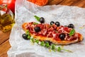 Delicious bread toast with natural tomato, extra virgin olive oil, Iberian ham, black olives and basil leaves. Royalty Free Stock Photo